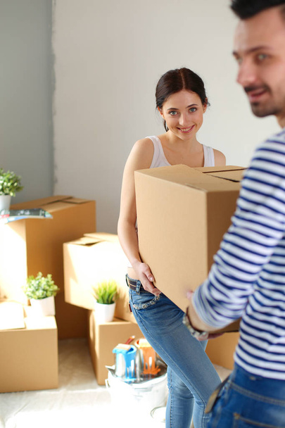 Happy young couple unpacking or packing boxes and moving into a new home. young couple - Foto, Bild