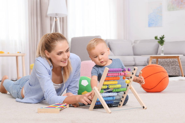 赤ちゃんと母親のおもちゃそろばん自宅で遊んで - 写真・画像