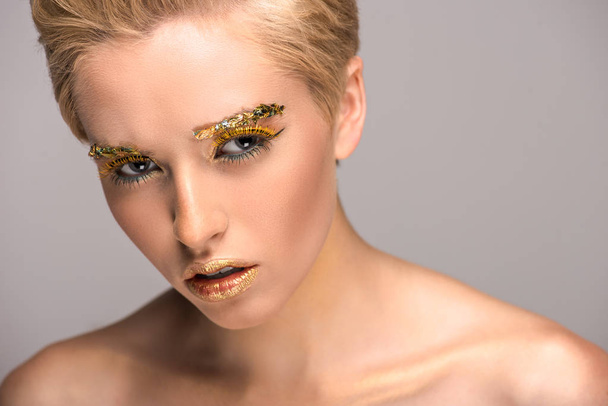 atractiva mujer irritada con maquillaje brillante dorado aislado en gris
 - Foto, Imagen