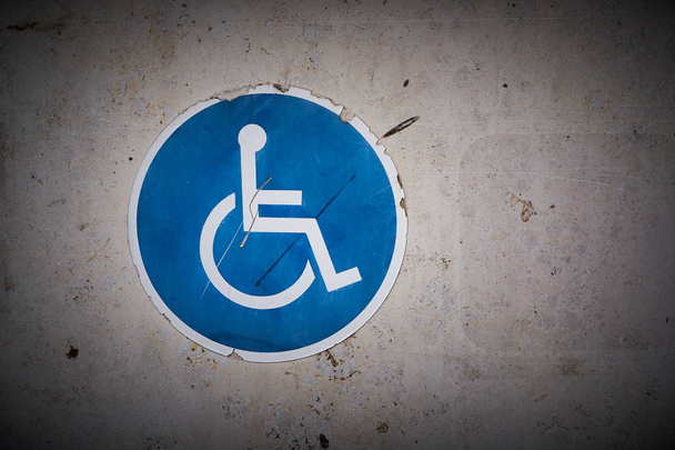   Vammaisen pysäköintipaikan tunnus pysäköintihallin seinällä
                              - Valokuva, kuva