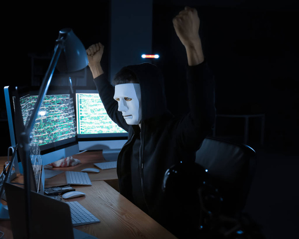 Masked hacker using computer  - Photo, Image