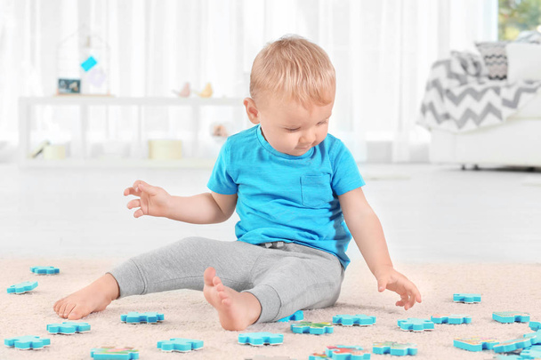 Cute little boy playing with puzzle at home - Fotoğraf, Görsel