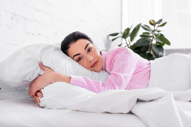 rózsaszín pizsama reggel otthon az ágyban pihenő nő portréja - Fotó, kép