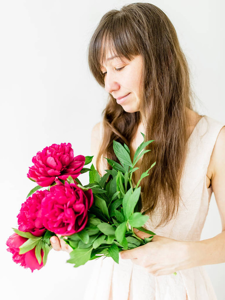 fotó boldog barna nő, rózsaszín virágok elszigetelt fehér background - Fotó, kép