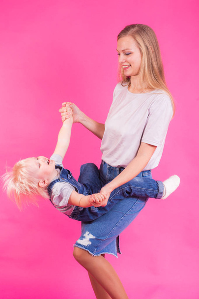 młoda matka i córka razem zabawy na różowym tle - Zdjęcie, obraz