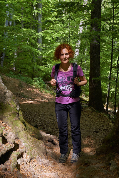 Woman hiker with backpack on a trail in the mountains - Fotoğraf, Görsel