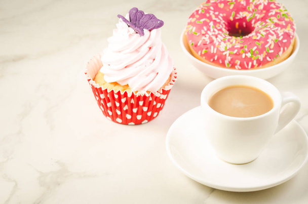 cappuccino white cup and fresh cake with butterfly/cappuccino white cup and fresh cake with butterfly on a white marble background. Selective focus and copyspace - Photo, image