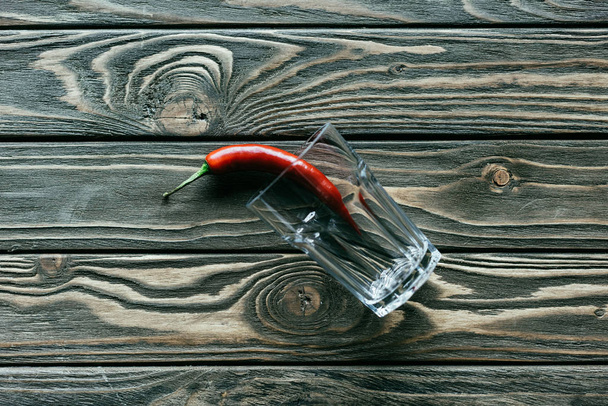 Красный перец чили в стекле на деревянном столе
 - Фото, изображение