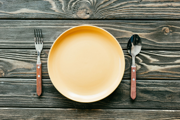Plate with cutlery set on wooden table - Photo, Image