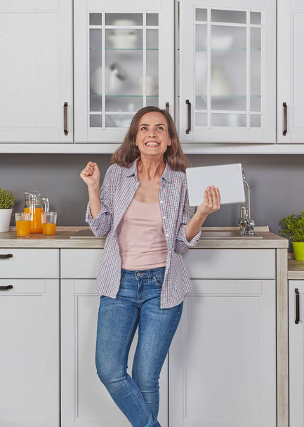 Woman in kitchen with digital tablet - Fotó, kép