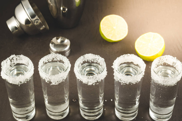 shots of tequila and pieces of lime and shaker/shots of tequila and pieces of lime and shaker. Top view - Photo, image