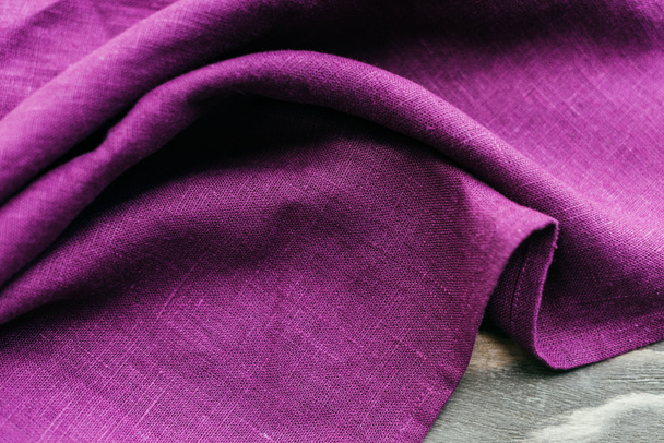 Textile purple napkin on wooden table - Photo, Image