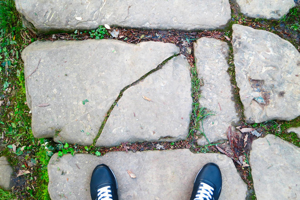 Las piernas son visibles desde arriba. Camino pavimentado con piedras grandes. Selfie es ideal para cualquier uso. Espacio libre
.  - Foto, Imagen