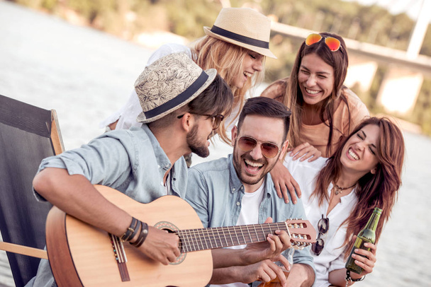 ember gitározni barátok ülve, a strand, piknik idő - Fotó, kép