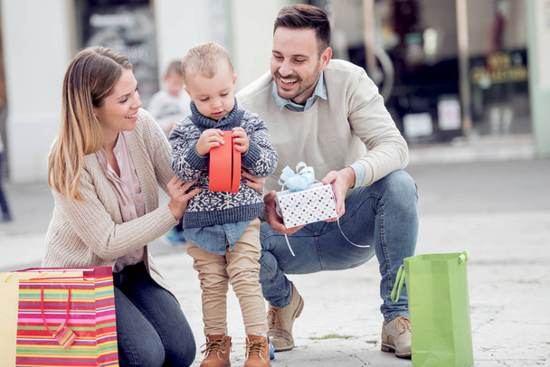 Портрет счастливой семьи, гуляющей после шоппинга в городе
 - Фото, изображение