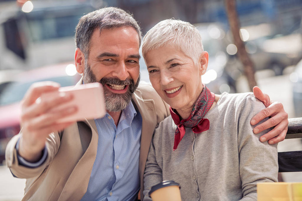 Feliz pareja madura tomando selfie en el teléfono inteligente al aire libre
  - Foto, imagen