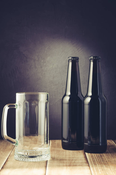 taza de cerveza vacía y botella / taza de cerveza vacía y botella en un estilo oscuro. Enfoque selectivo
 - Foto, Imagen