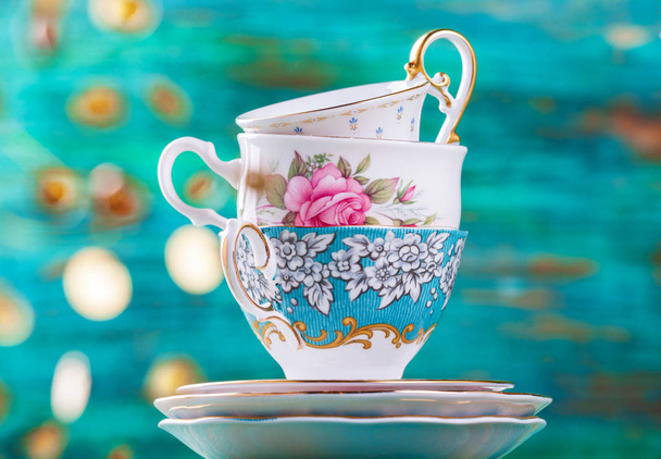Стопка старинных чашек чая на бирюзовом фоне
 - Фото, изображение