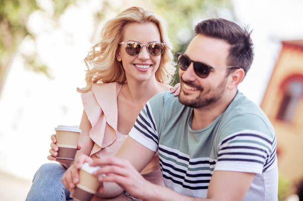 couple spending time together and drinking coffee outdoors at daytime - Foto, Imagen