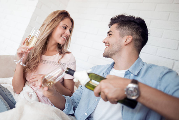 jovem casal beber vinho de óculos em casa
 - Foto, Imagem