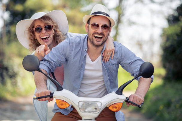 jeune couple s'amuser ensemble tout en roulant sur scooter
 - Photo, image