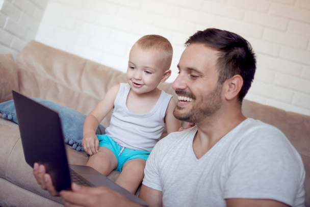 happy father and little son watching cartoons on laptop  - Foto, Imagen