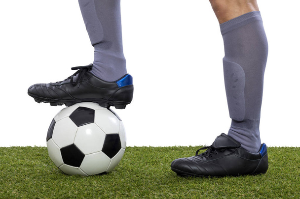 detail of soccer player feet stepping on a ball over the grass on white background - Photo, image