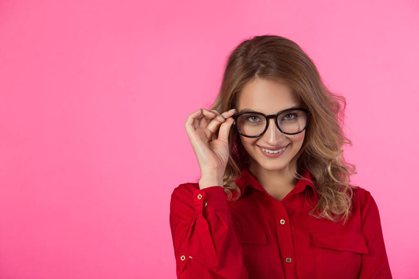 beautiful joyful young girl in a red shirt on a pink background - Foto, Imagem