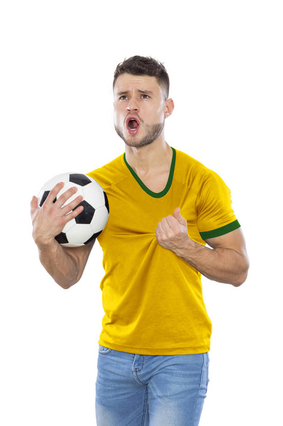 Jovem fã de futebol com camisa amarela e verde com bola nas mãos sobre fundo branco
 - Foto, Imagem
