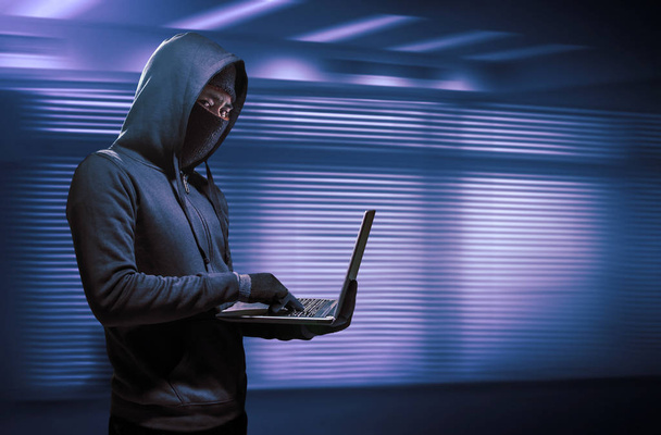 Haker korzystający z laptopa. Włamywanie się do Internetu. - Zdjęcie, obraz