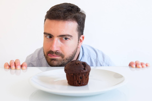 Γλυκό δόντι άνθρωπος σε δίαιτα στον πειρασμό από κέικ σοκολάτας - Φωτογραφία, εικόνα