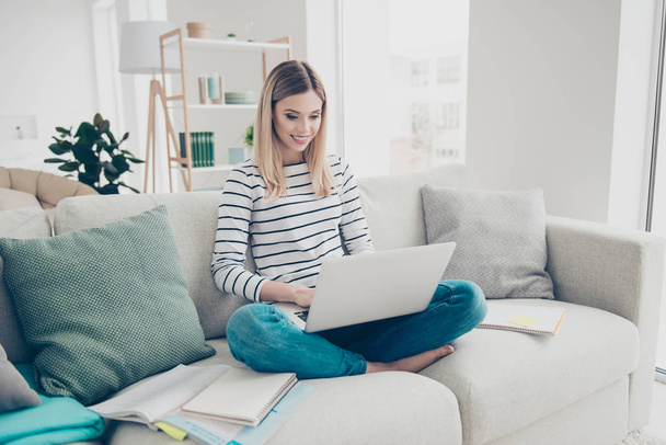 Portrait of pretty, charming, nice, clever, smart, educated, good, stylish girl preparing for lesson, sitting at home in livingroom doing exercise, using laptop, wearing striped outfit, jeans - 写真・画像