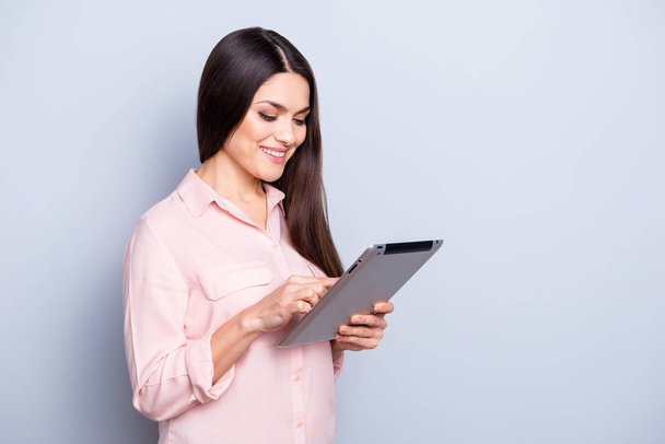 Portrait with copy space empty place of pretty charming confident trendy woman in classic shirt having tablet in hands, expertising analyzing, isolated on grey background - Фото, зображення