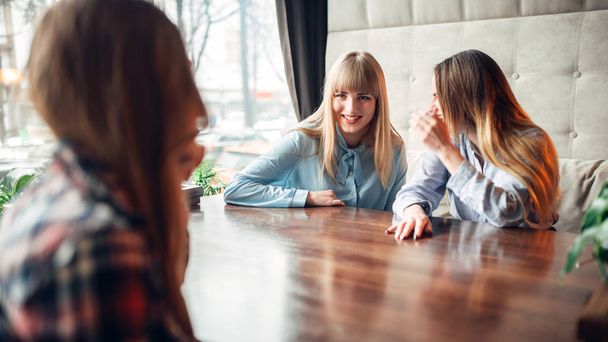 happy young female friends talking in cafe - Фото, зображення