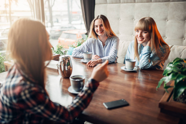 τρεις ευτυχισμένος θηλυκό φίλους πίνοντας τον καφέ στην καφετέρια - Φωτογραφία, εικόνα