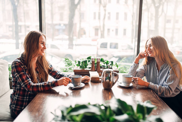 two happy female friends drinking coffee in cafe - Foto, immagini