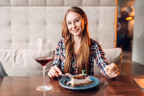 チョコレートのデザート、レストランで赤ワインを持つ若い女性の肖像画 - 写真・画像