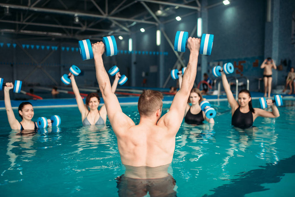 aqua aerobics workout with dumbbells in water sport center, indoor swimming pool, recreational leisure - Photo, Image