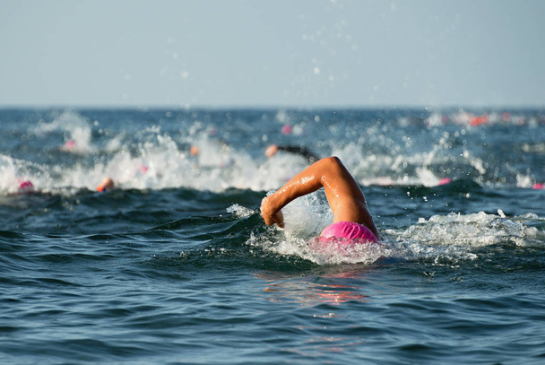Ryhmä ihmisiä märkäpuku uinti triathlon
 - Valokuva, kuva