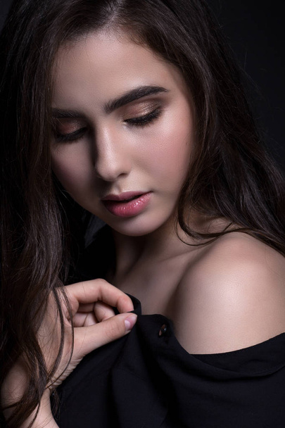 Classic portrait of a teenage girl in a black shirt on a black background, close-up. with evening make-up. - Fotografie, Obrázek