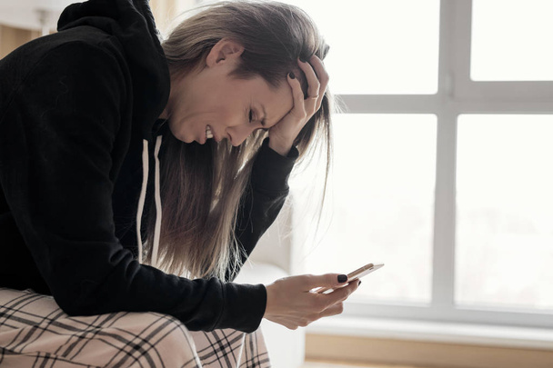 Женщина держит телефон и плачет
 - Фото, изображение