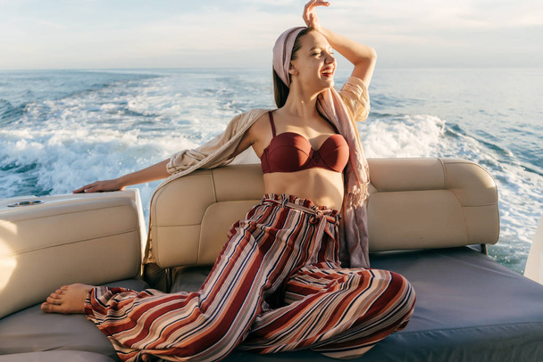 a luxurious stylish woman in summer clothes relaxes on her yacht, sails on the Caribbean sea - Foto, Bild