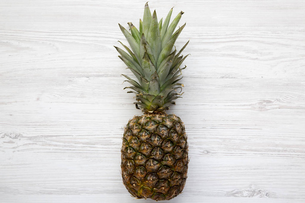 Ripe pineapple on a white wooden background. From above. Top view. - Foto, Bild
