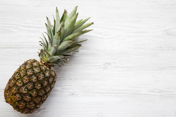 Large ripe pineapple on a white wooden background with copy space. From above. Top view. - 写真・画像