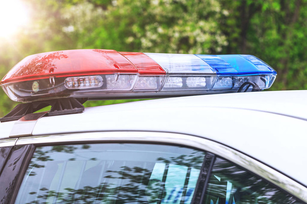 Streifenwagen der Polizei mit Sirenen bei einer Verkehrskontrolle. Blaue und rote Sirenen von Polizeiautos während der Straßensperrung in der Stadt.  - Foto, Bild