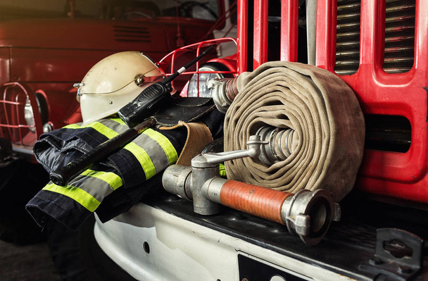 Equipo de bomberos en camión de bomberos como cañón de fuego, ropa especial, ración, casco e hidrante
 - Foto, imagen
