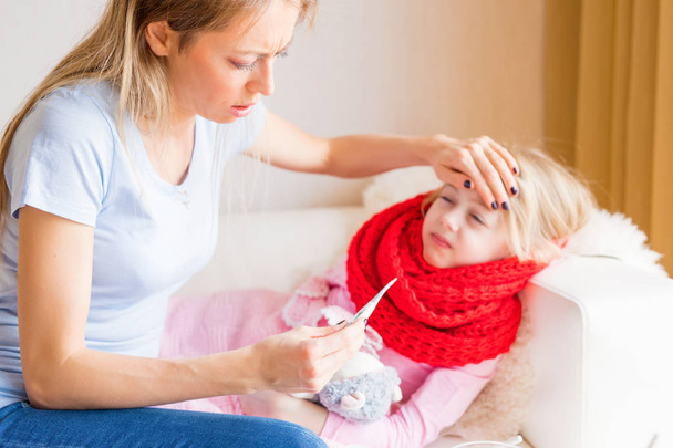 Mãe medir a temperatura de sua filha doente
 - Foto, Imagem