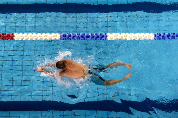 若い男性水泳プール車線ライン、水しぶきで自由形を行使 - 写真・画像