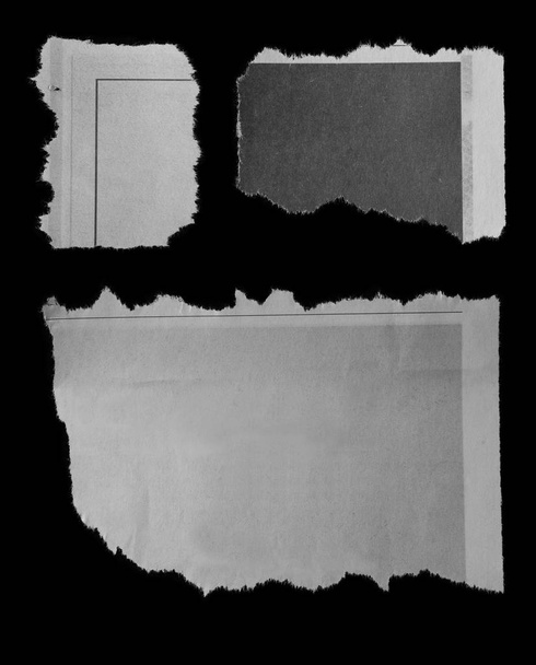 Три куска рваной бумаги на черном
 - Фото, изображение