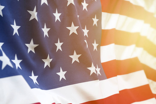 Крупный план неровного американского флага. Солнечный свет, сияющий с конца
 - Фото, изображение